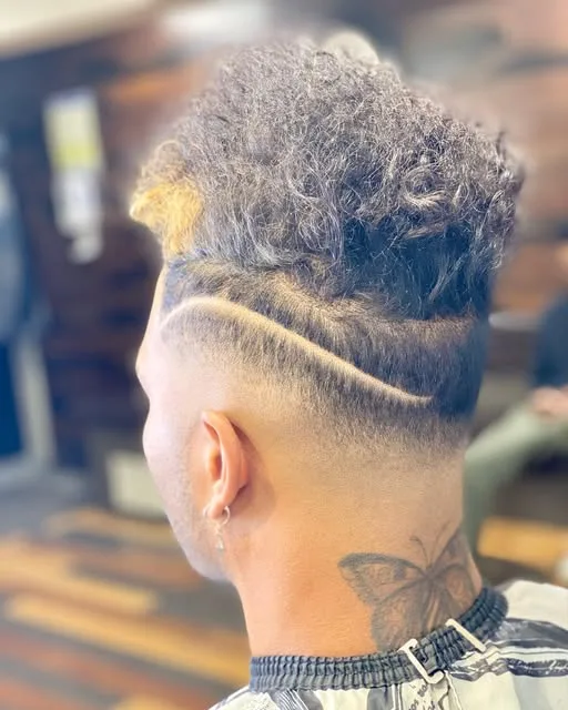 Curly mohawk with a shaved line design on the side